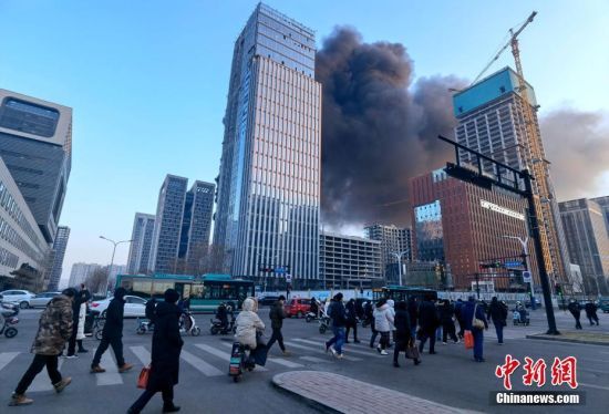 1月6日，位于山东省济南市历下总部商务中心工地突发火灾，现场浓烟滚滚。济南市消防救援支队接警后，指挥中心立即调派消防员赶赴现场处置。 中新社发 钱程 摄
