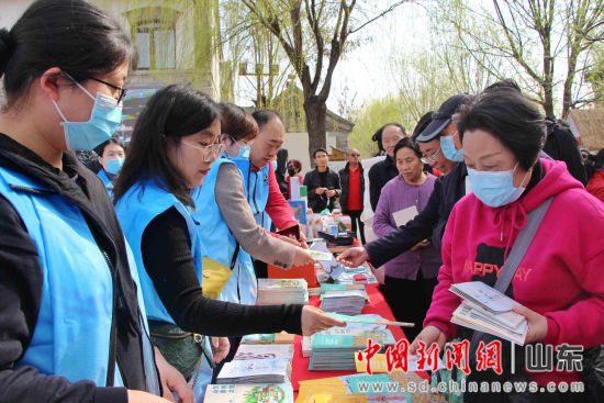 图为工作人员在现场为民众发放文旅宣传页、旅游地图指南等。赵晓 摄