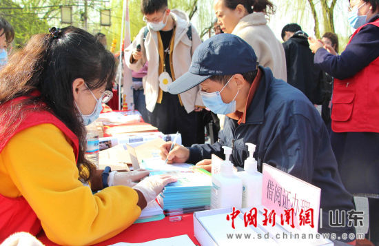 图为民众在现场办理图书馆借阅证。赵晓 摄