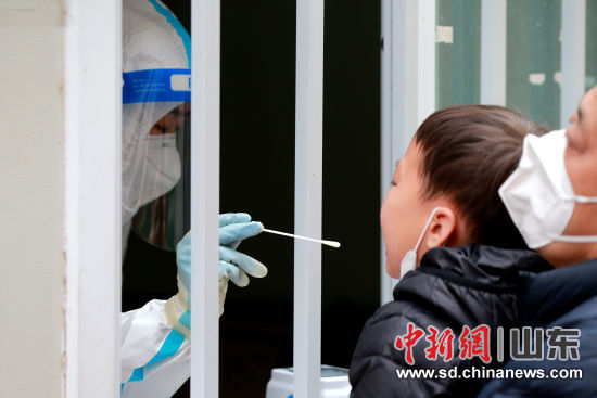 医护人员在港沟街道办事处社区卫生服务中心核酸检测采样点进行咽拭子采样。梁? 摄