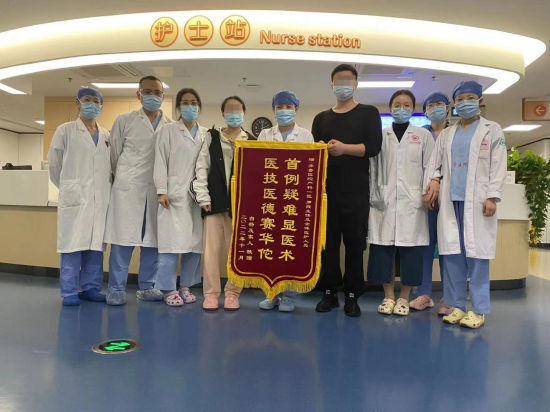图为患者康复出院，为医院团队送上锦旗。