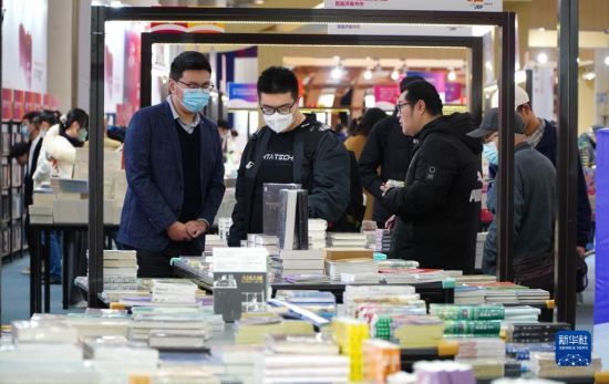 　2月25日，在首届济南书市上，读者在挑选图书。