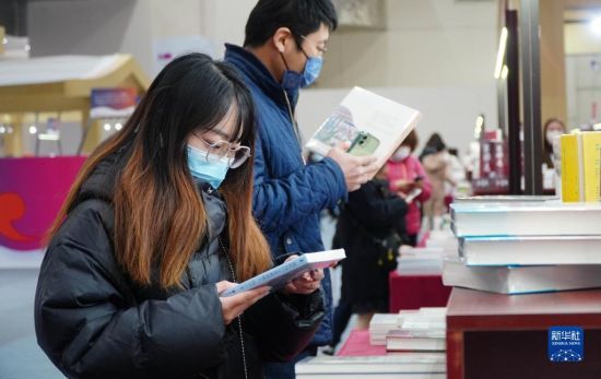 　2月25日，在首届济南书市上，读者在挑选图书。