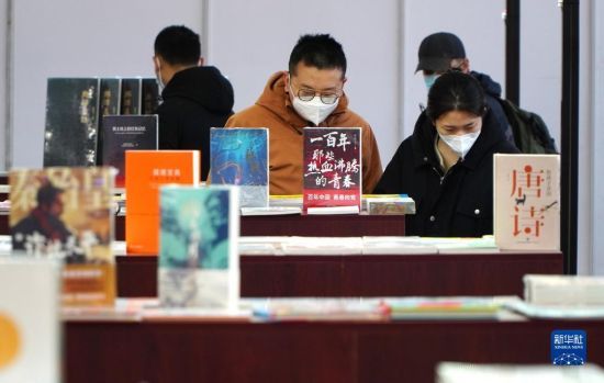 　2月25日，在首届济南书市上，读者在挑选图书。
