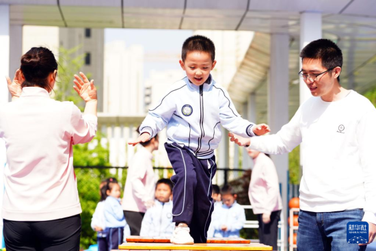 　4月27日，在济南市市中区山望幼儿园，家长和孩子在做亲子互动游戏。