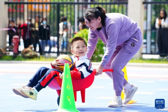 　4月27日，在济南市市中区山望幼儿园，家长和孩子在做亲子互动游戏。