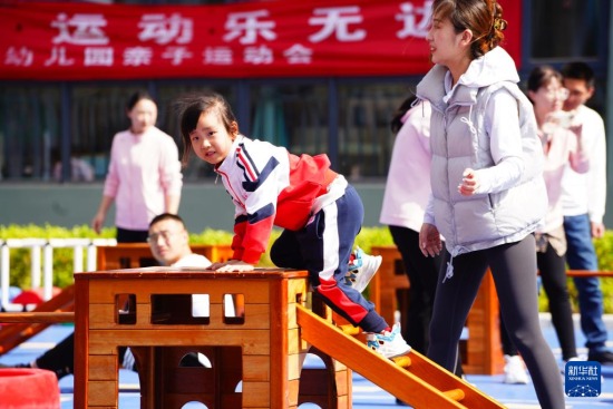 　4月27日，在济南市市中区山望幼儿园，家长和孩子在做亲子互动游戏。