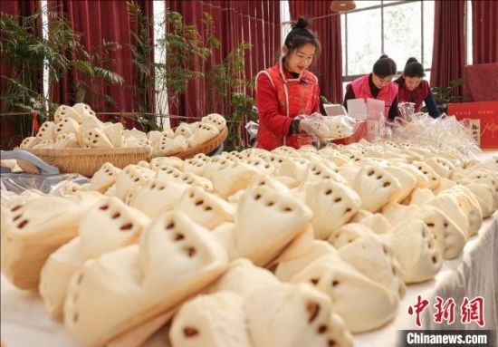 　　1月24日，在山东荣成石岛管理区一家民宿餐厅，工作人员在蒸制、包装花饽饽。李信君 摄