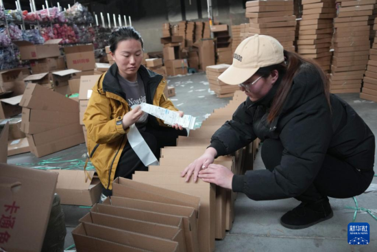 2月18日，在山东省潍坊市坊子区王家庄子村一家风筝企业，工作人员为网络销售的风筝外包装贴上发货信息单。