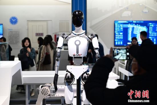 图为参观者在拍摄展出的人形机器人T1 Pro。