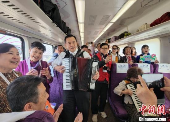 4月10日，山东济南，列车上的“银发”乘客拉着手风琴、唱着歌，庆祝列车投入运营。中新社记者 赵晓 摄